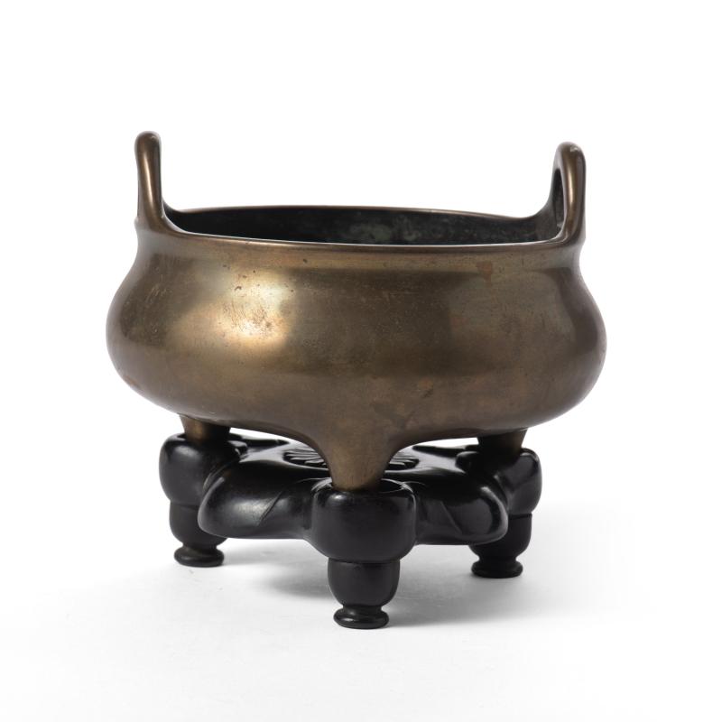 A gilt bronze loop-handled tripod censer