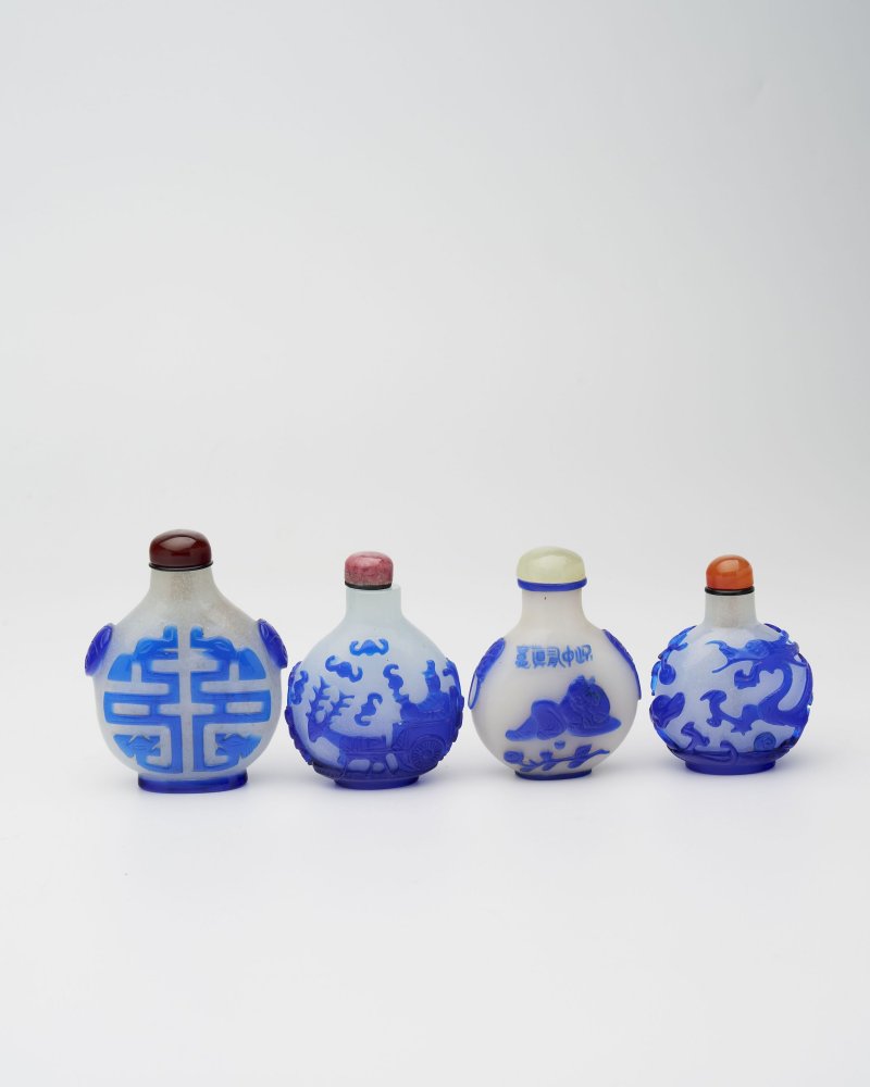 十九/二十世紀 白地套藍玻璃行龍紋、人物紋、仙翁駕鹿紋、團壽紋鼻煙壺四件 | FOUR BLUE OVERLAY GLASS SNUFF BOTTLES