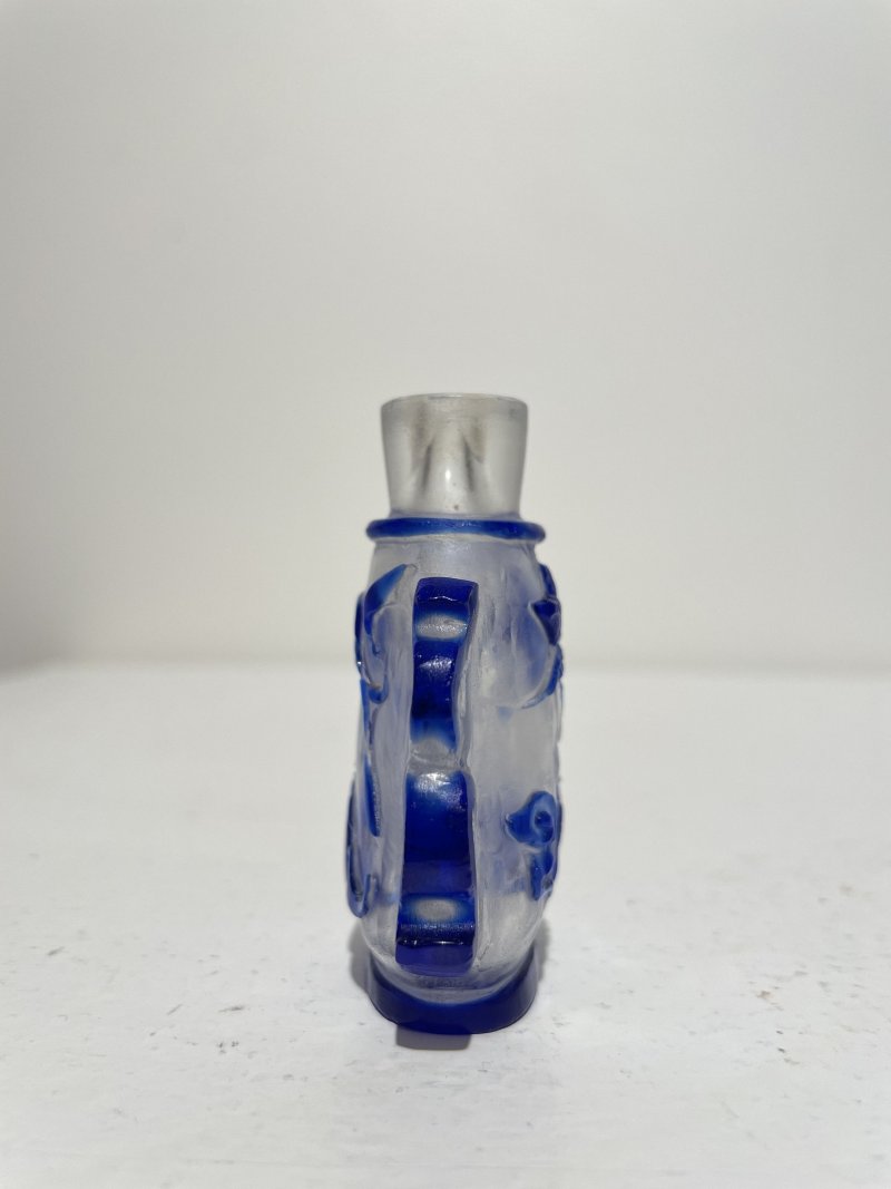 十九/二十世紀 藍玻璃竹簍紋、霏雪地套藍玻璃開光八駿紋、素面開光、透明地套藍玻璃蝴蝶花卉紋鼻煙壺四件 | THREE BLUE OVERLAY GLASS AND A SAPPHIRE-BLUE GLASS SNUFF BOTTLES - 图36