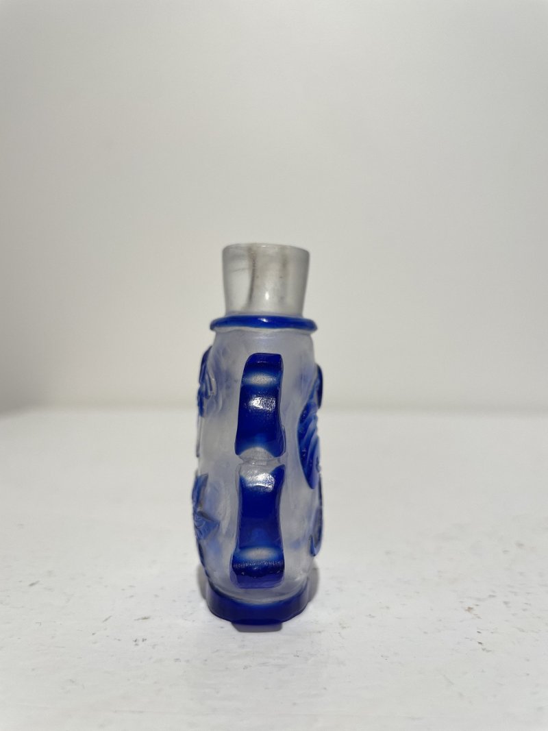 十九/二十世紀 藍玻璃竹簍紋、霏雪地套藍玻璃開光八駿紋、素面開光、透明地套藍玻璃蝴蝶花卉紋鼻煙壺四件 | THREE BLUE OVERLAY GLASS AND A SAPPHIRE-BLUE GLASS SNUFF BOTTLES - 图38