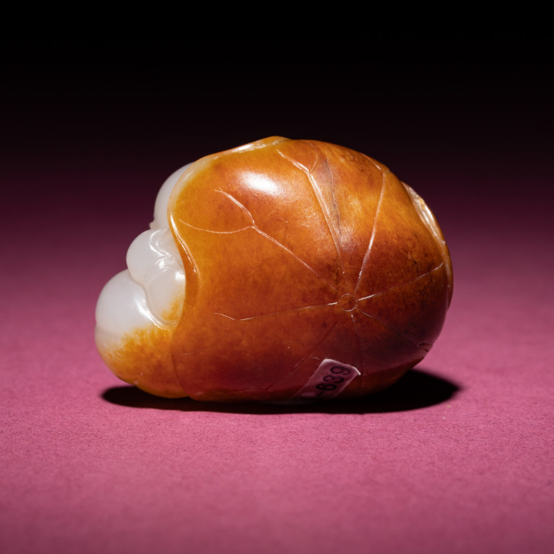 清中期 白玉留皮童子持荷把件 | A Chinese Russet and White Jade Carving of a Boy with Lotus Pad, 18th/19th Century - 图2