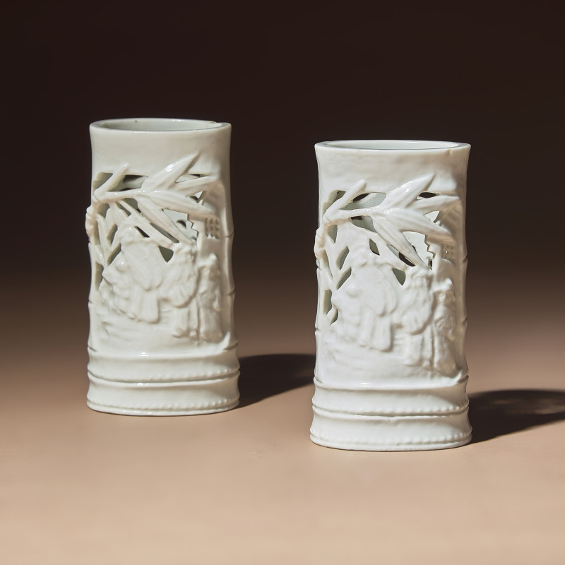 清早期 德化白瓷鏤雕竹林七賢筆筒一對 | A Pair of Chinese Blanc-de-Chine Reticulated Porcelain 'Scholars' Brush Pots, Bitong, 17th-18th Century - 图1