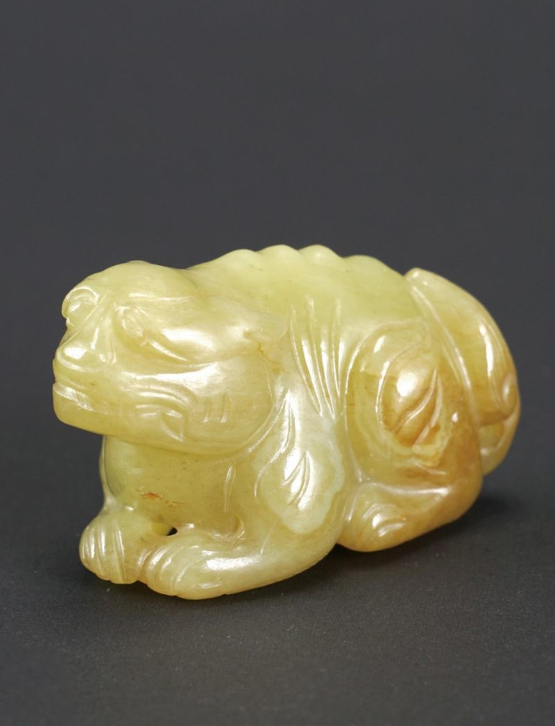    清 和田青黃玉臥獸手把件