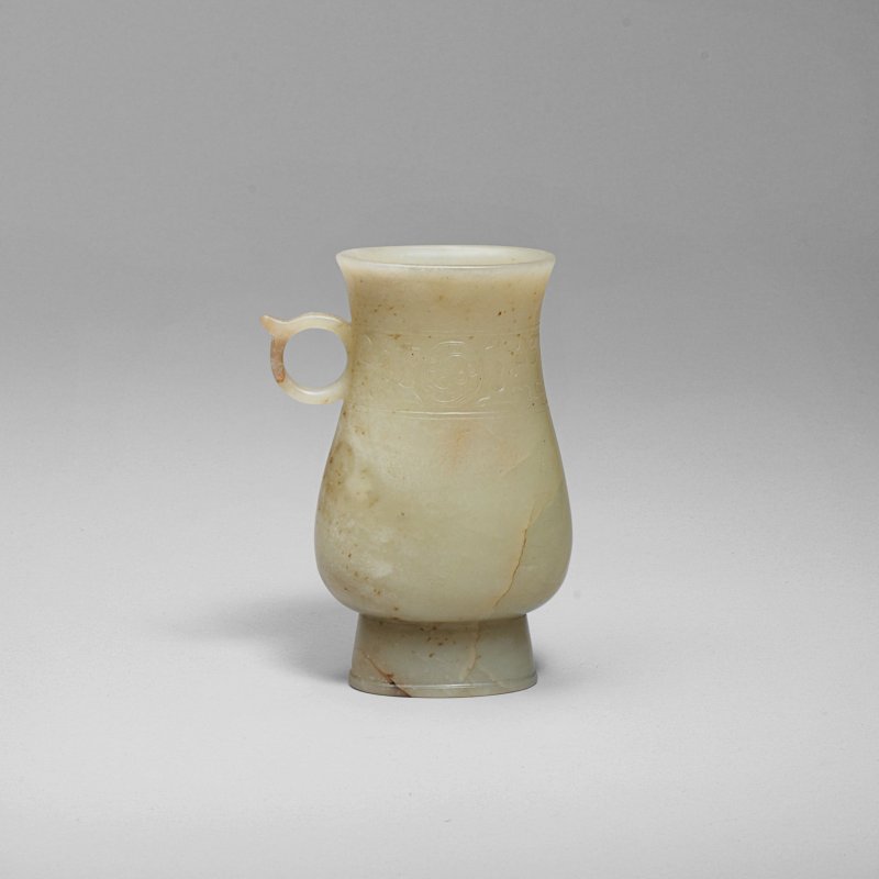 明 青玉仿古夔鳳紋單柄觶 | AN ARCHAISTIC PALE GREEN AND RUSSET JADE VESSEL, ZHI