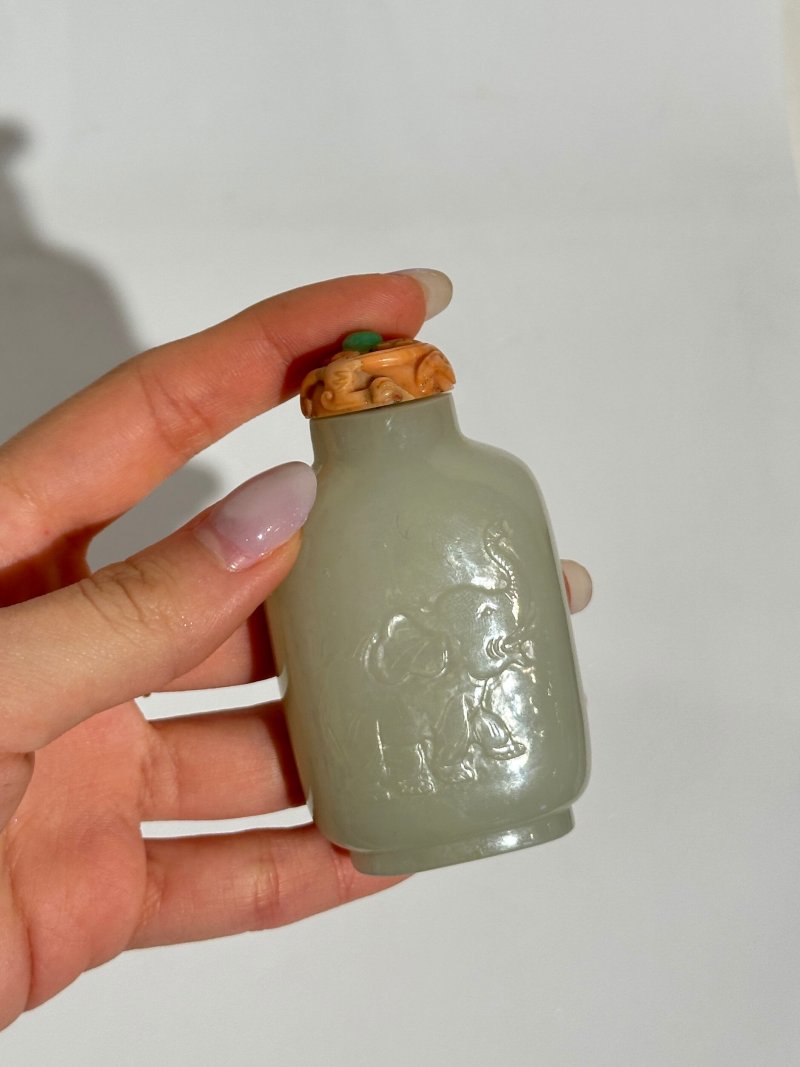 十九/二十世紀 白玉帶皮巧雕⌈出將入相⌋鼻煙壺、珊瑚鑲翡翠蓋 | A WHITE AND RUSSET JADE 'ELEPHANT' SNUFF BOTTLE - 图3