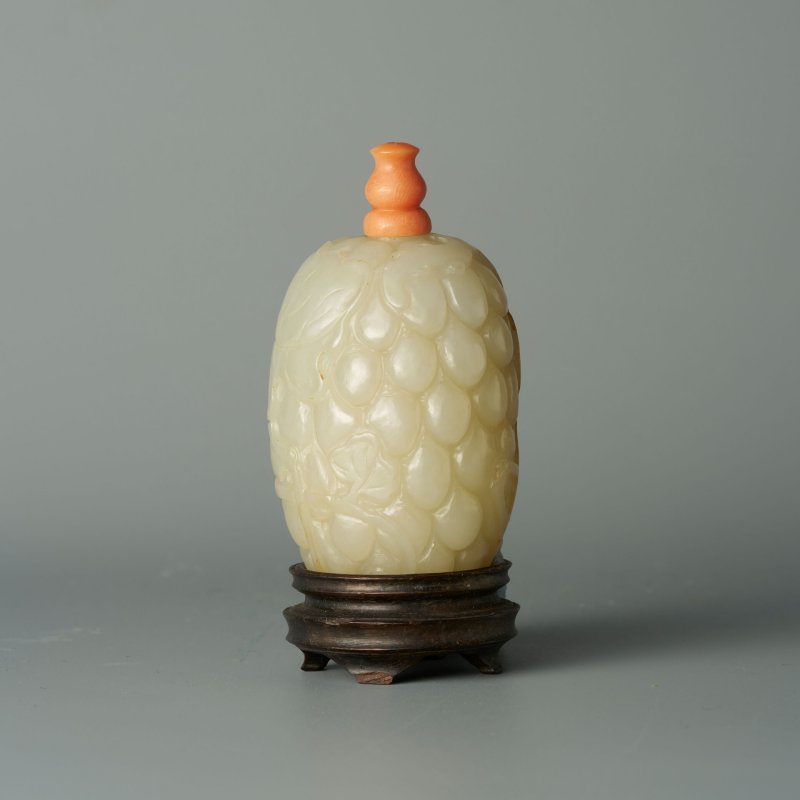 清十九世紀 白玉帶皮巧雕葡萄紋鼻煙壺、珊瑚蓋 及座 | A WHITE JADE 'GRAPES' SNUFF BOTTLE WITH RUSSET INCLUSION - 图1