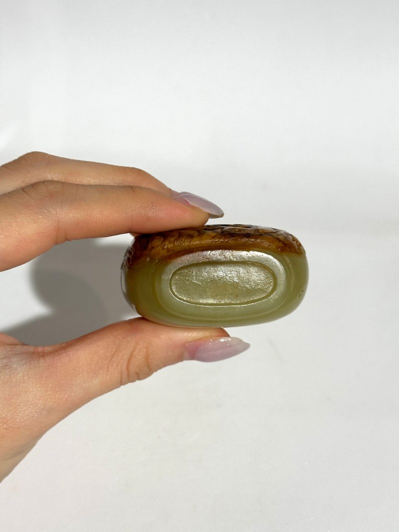 清十八/十九世紀 卵石皮浮雕大師流派青玉帶皮巧雕松下童子紋鼻煙壺、珊瑚蓋 | A GREEN AND RUSSET JADE SNUFF BOTTLE - 图2