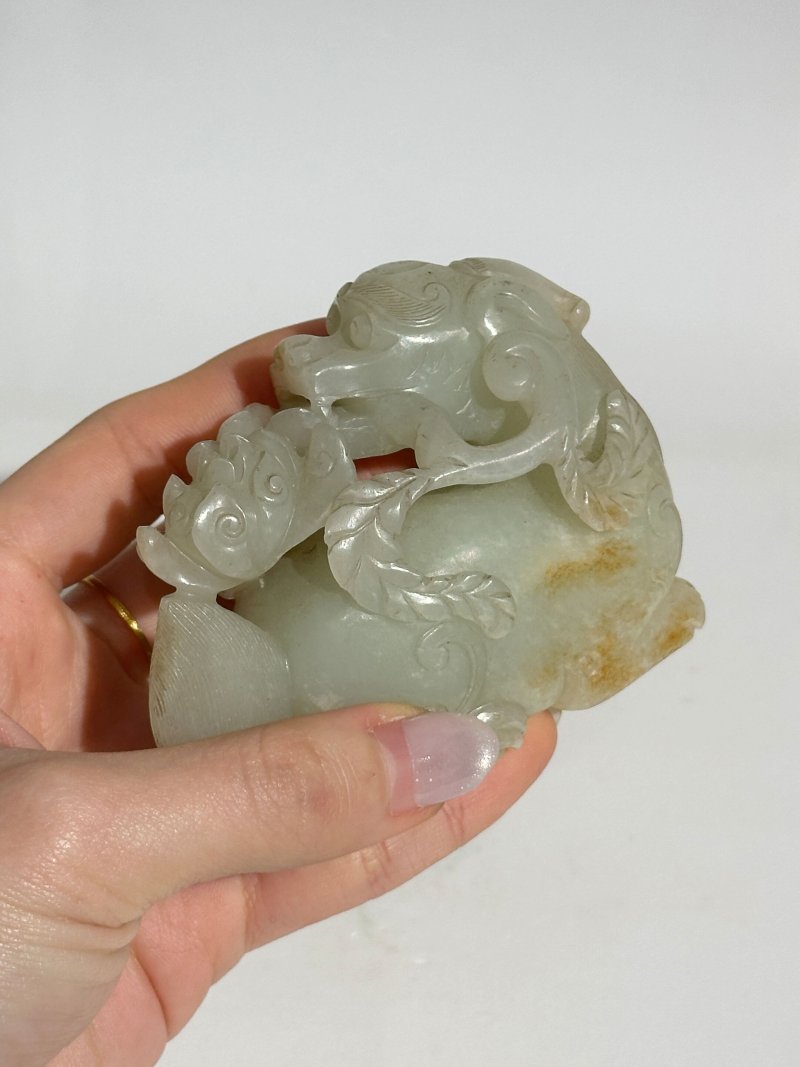 清 青白玉瑞獸銜花擺件 及座 | A GREENISH WHITE JADE 'DOG' CARVING WITH RUSSET INCLUSION - 图2