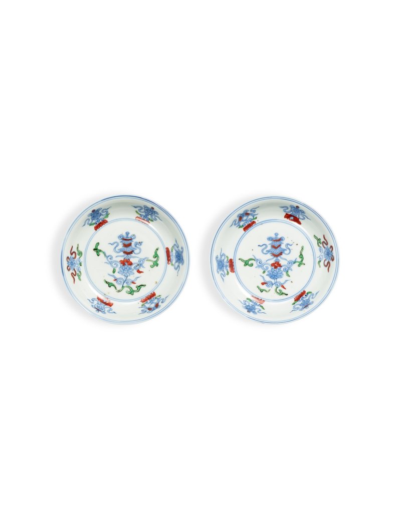 A fine pair of wucai 'Buddhist emblems’ saucers, Marks and period of Wanli | 明萬曆　青花五彩八吉祥小盤一對　《大明萬曆年製》款