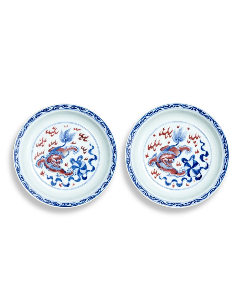A fine pair of underglaze-blue and copper-red ‘Buddhist lion and brocade ball’ dishes, Seal marks and period of Qianlong | 清乾隆　青花釉裏紅獅子戲球盤一對　《大清乾隆年製》款
