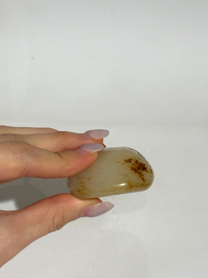 十九/二十世紀 白玉褐沁隨形祥雲蝠紋鼻煙壺、珊瑚蓋 | A WHITE AND RUSSET JADE PEBBLE-SHAPED SNUFF BOTTLE - 图2