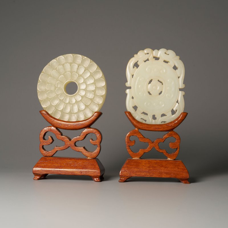 十九/二十世紀 青玉菊紋佩、及白玉輪紋佩二枚 及座 | A GREEN JADE 'CHRYSANTHEMUM' AND A WHITE JADE 'WHEEL' PENDANT - 图1