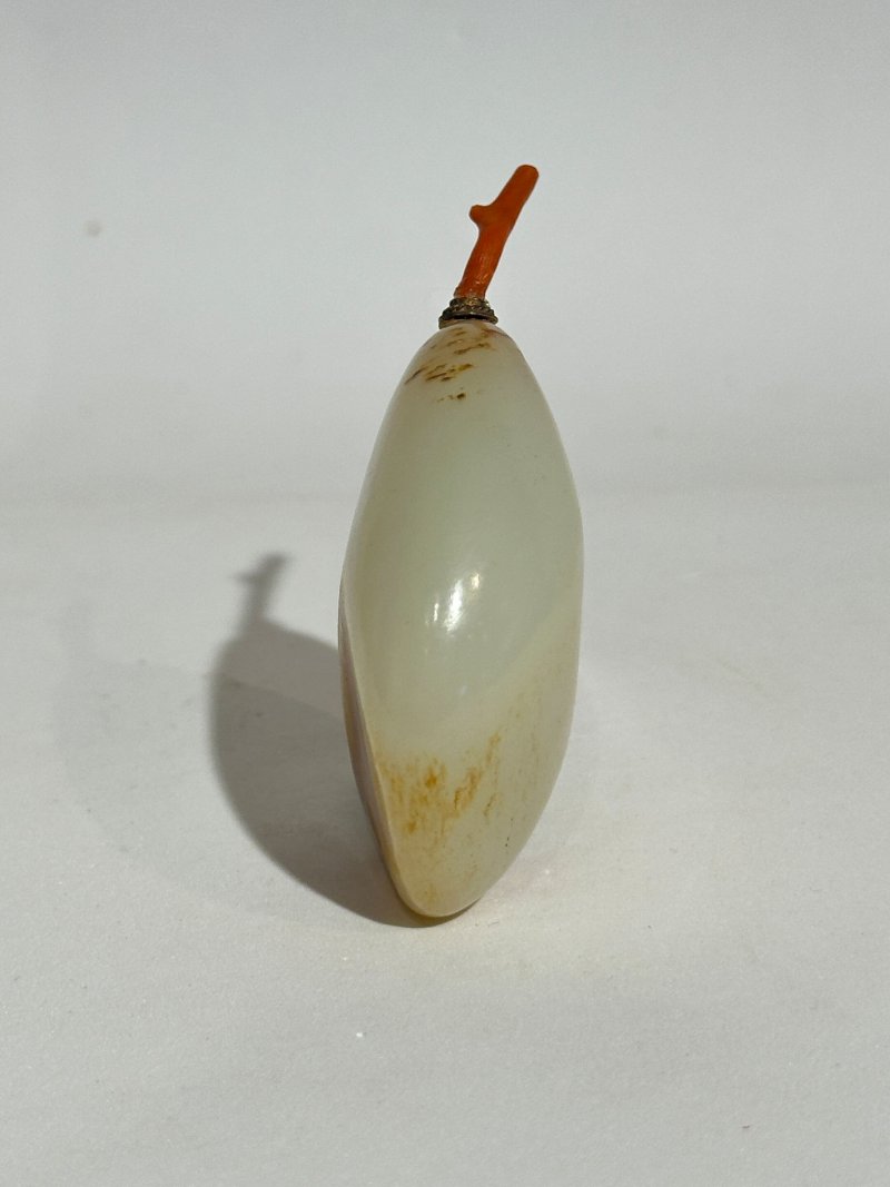 十九/二十世紀 白玉褐沁隨形祥雲蝠紋鼻煙壺、珊瑚蓋 | A WHITE AND RUSSET JADE PEBBLE-SHAPED SNUFF BOTTLE - 图6