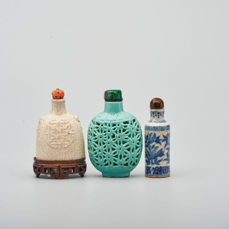 清道光及其後 漿胎白釉壽紋、綠松釉鏤雕菊紋、漿胎青花三多紋鼻煙壺三件、（⌈壽⌋）珊瑚蓋 及座 | THREE CERAMIC SNUFF BOTTLES