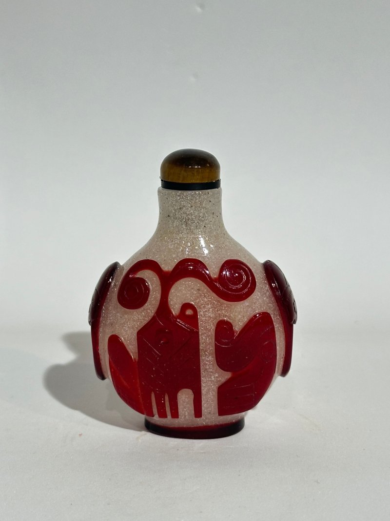十九/二十世紀 白地套紅玻璃雙花紋、白地套三色玻璃花卉紋、透明地套紅玻璃壽字紋、涅白地套紅玻璃蝶花紋、霏雪地套紅玻璃一言九鼎紋、三腳鼎立紋、博古紋、透明地套黑玻璃一言九鼎紋鼻煙壺八件 | EIGHT OVERLAY GLASS SNUFF BOTTLES - 图28