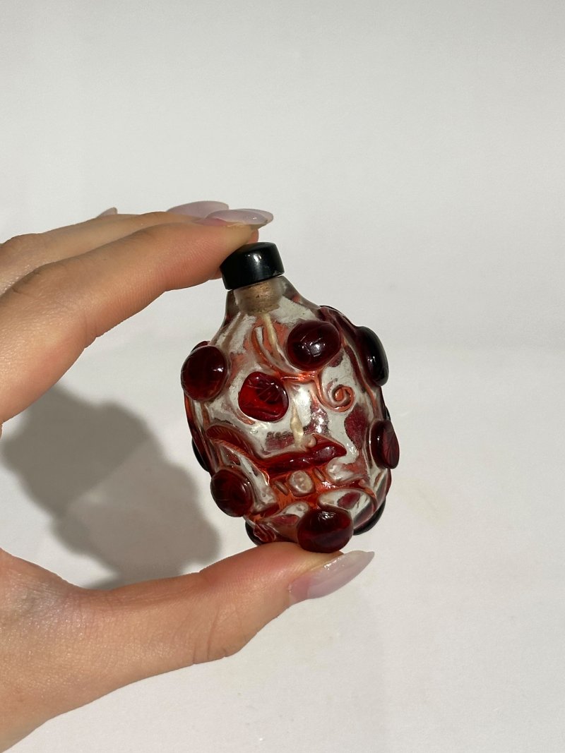 清十九世紀 棕地套綠玻璃僧侶持蓮紋、透明地套紅玻璃松鼠葡萄紋鼻煙壺二件 | A GREEN OVERLAY BROWN GLASS 'MONK HOLDING A LOTUS' AND A RED OVERLAY GLASS 'SQUIRREL' SNUFF BOTTLE - 图11