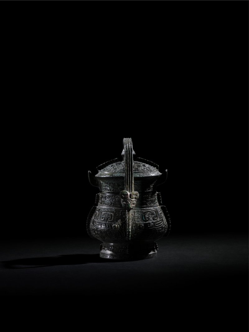 An exquisite and remarkably rare miniature bronze royal ritual wine vessel and cover, You, Late Shang dynasty | 商晚期 青銅弄器提梁卣 - 图1