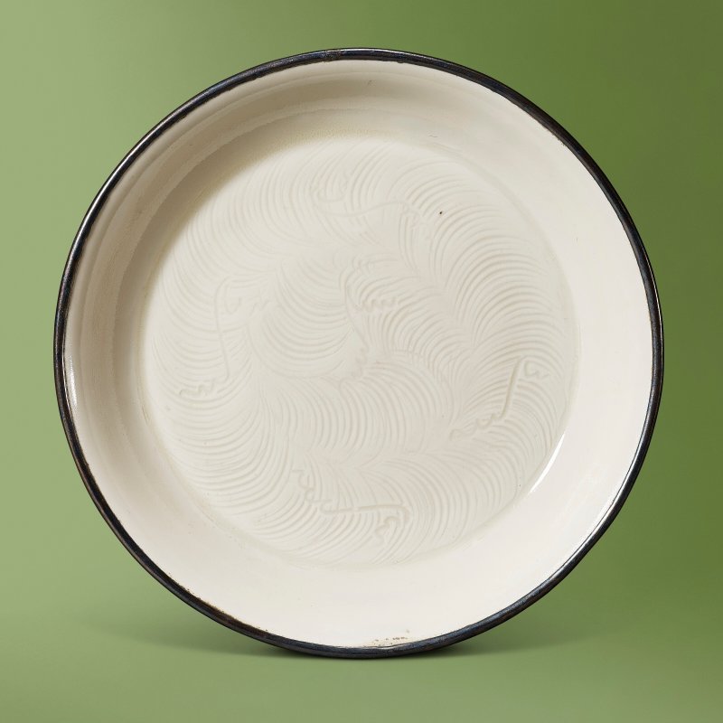 A DING WHITE-GLAZED CARVED ‘WAVE’ DISH  CHINA, NORTHERN SONG DYNASTY (960-1127)
