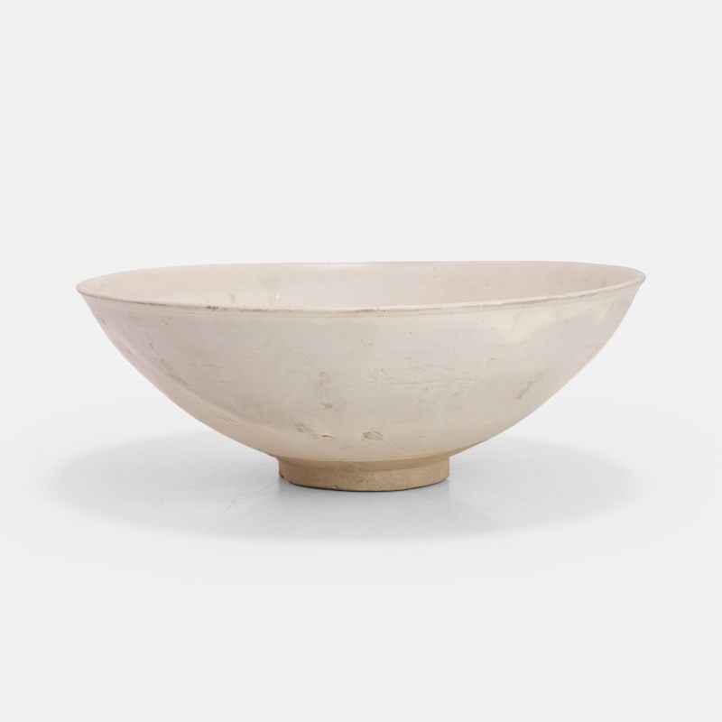 金 白釉刻花荷花纹碗 | A Chinese white-glazed bowl Jin dynasty (1115-1234), the rounded sides rising from a circular foot to a slightly flared rim