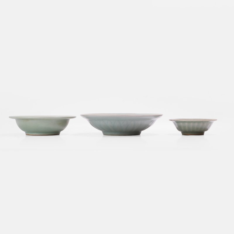 元 龙泉窑青釉双鱼纹盘 一组三件 | Three Chinese Longquan celadon-glazed plates Yuan dynasty (1271-1368), each with rounded sides rising to a broad everted rim - 图1