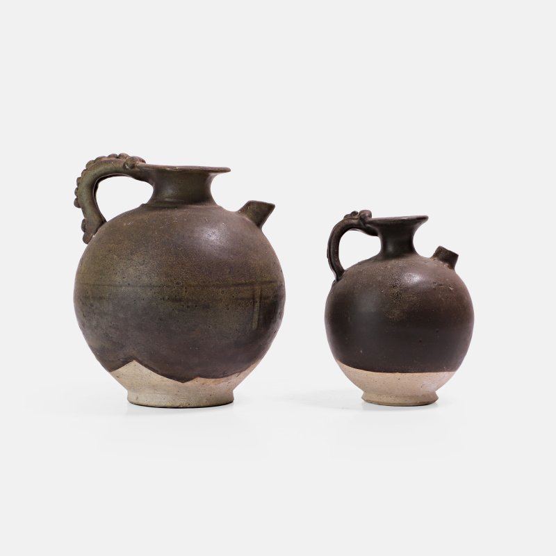 唐 黑釉壶 一组两件 | Two Chinese stoneware ewers Tang dynasty (618-907), each of ovoid form with one handle in the shape of a stylised dragon clasping the rim - 图1