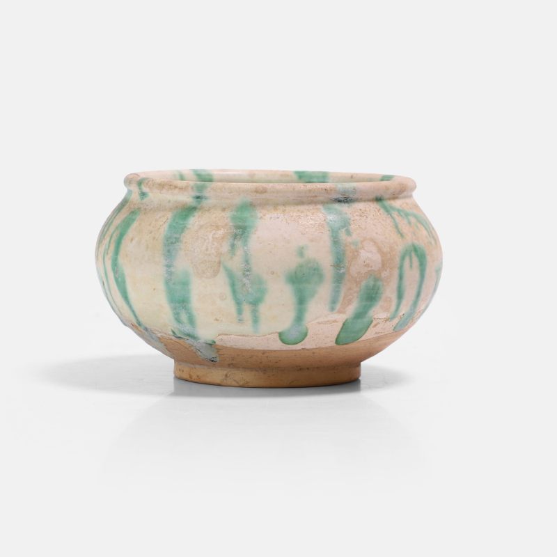 唐 白釉绿彩罐 | A Chinese sancai-glazed jar Tang dynasty (618-907), the compressed globular body rising from a short straight foot to a slightly incurved mouth with a lipped rim