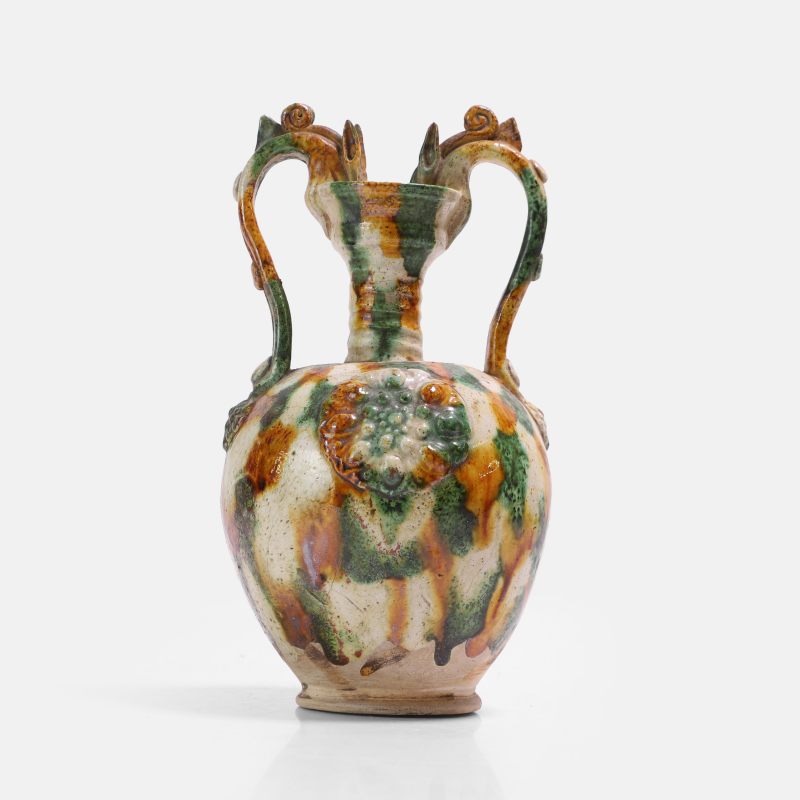 唐 三彩贴花弦纹双龙耳盘口尊 | A Chinese sancai-glazed two-handled 'amphora' vase Tang dynasty (618-907), the well-potted ovoid body applied with medallions and a pair of dragons - 图2
