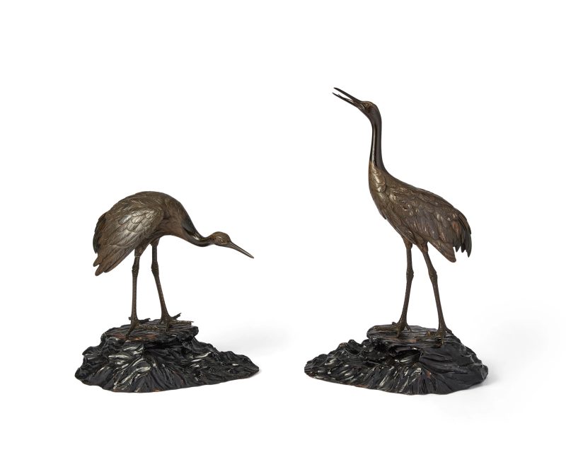 A pair of Japanese bronze figures of cranes