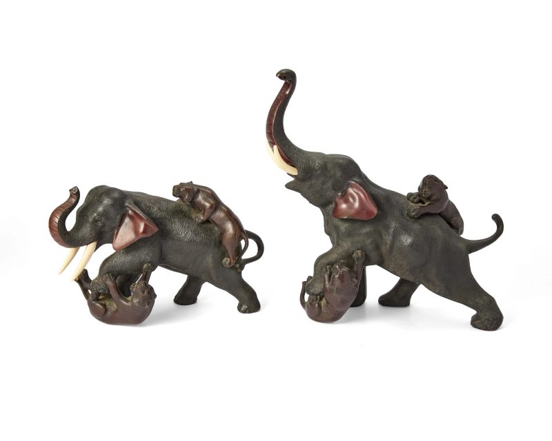 Two Japanese bronze okimono depicting tigers attacking an elephant